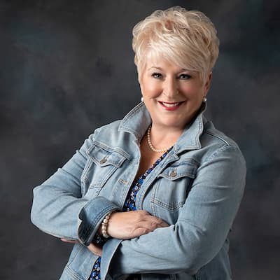 Portrait of Alice Annette Whited smiling in a denim jacket.