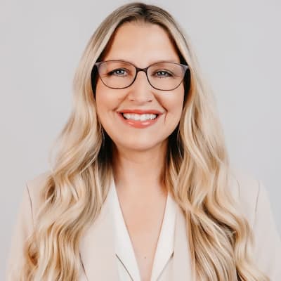 Professional woman with glasses smiling, representing financial services.