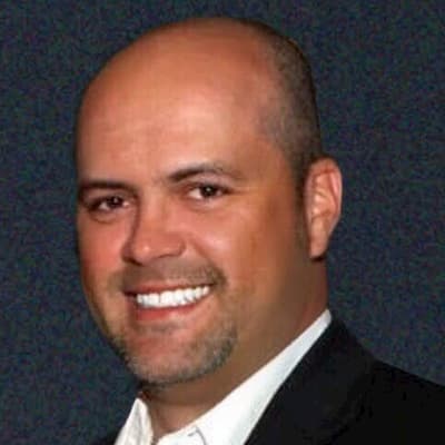 Alex Figueroa smiling, professional portrait for financial services.