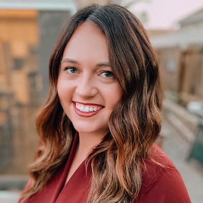 Professional woman smiling outdoors for financial success.