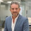 Professional portrait of Claudio Prunotto in business attire at office.
