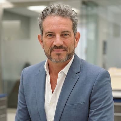 Professional portrait of Claudio Prunotto in business attire at office.