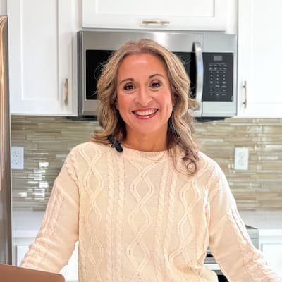 Chris Gonzalez smiling in a modern kitchen, promoting Preferred Rate mortgage services.