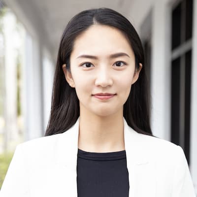 Professional portrait of Hongying Zhang outside modern building.
