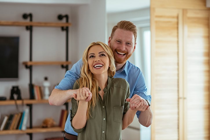 Happy couple exploring home buying options with down payment assistance programs.