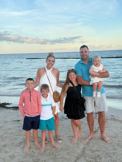 Family enjoying a beach sunset with kids and parents on the shoreline.
