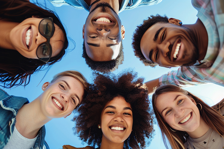 Below view of multiracial group of happy college friends at camp