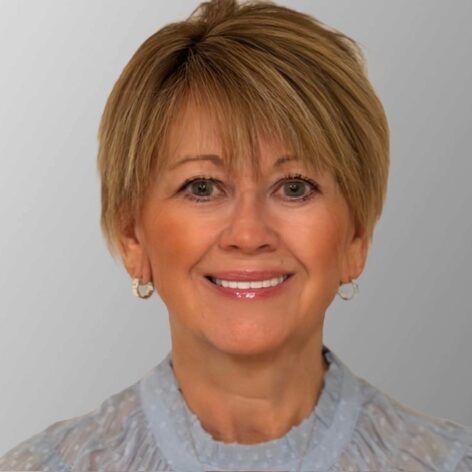 Portrait of Pam Rasmussen, smiling woman with short blonde hair.