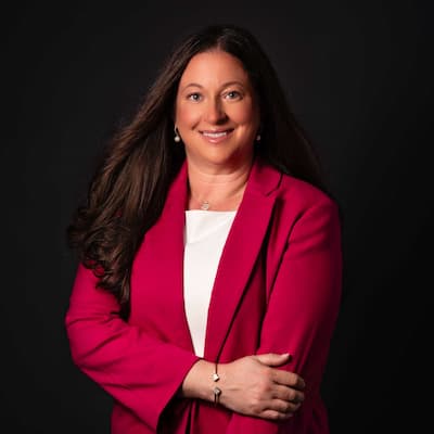 Amanda Vazquez smiling in a pink blazer, promoting financial services and expert advice.
