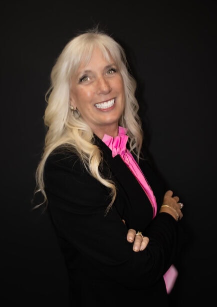 Portrait of Laurel Knight Keane smiling against a black background.