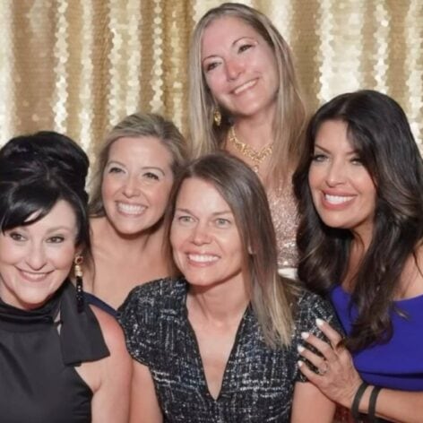 Group of women smiling at Preferred Rate event, celebrating success.