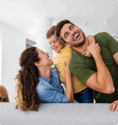 Happy family playing and laughing together in a cozy living room.
